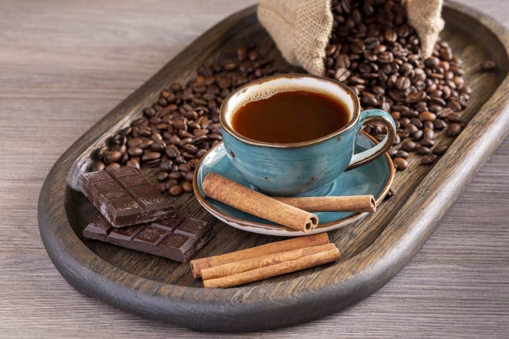 Eine Tasse aromatischer, schwarzer Kaffee mit Kaffeebohnen