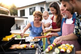 Eine Familie mit Kleinkind grillt zusammen im Sommer