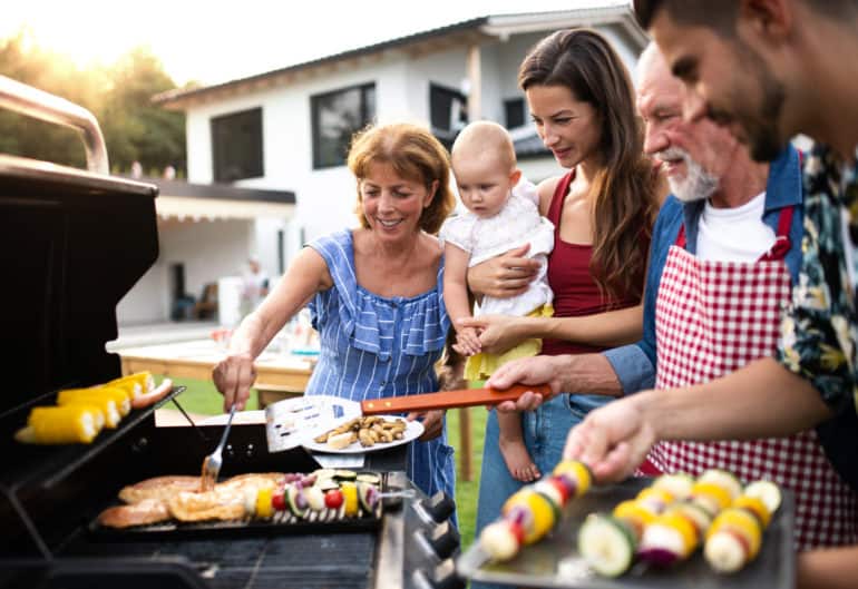 Eine Familie mit Kleinkind grillt zusammen im Sommer